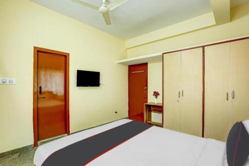 una camera con letto e TV a schermo piatto di Relax Suites a Bangalore