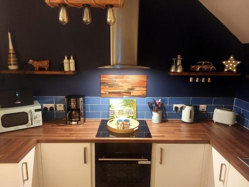 a kitchen with a counter top with blue tiles at The Lodge Dunrowan in Kyle of Lochalsh