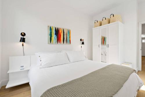 a white bedroom with a bed and a white cabinet at Haven Tiny House - Heated Pool - Walk To Downtown in Saint Augustine