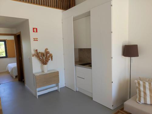 a kitchen with white cabinets and a table in a room at Ocean & Countryside Apartments in Encarnação