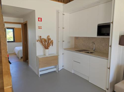 una cucina con armadi bianchi e lavandino di Ocean & Countryside Apartments a Encarnação