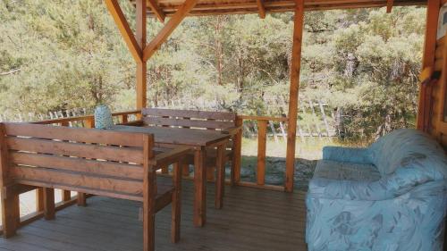 una mesa de madera y un banco en un porche en Treimani Hoovimaja, en Treimani