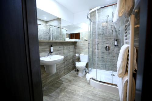 a bathroom with a sink and a toilet and a shower at Hotel Forma in Piła
