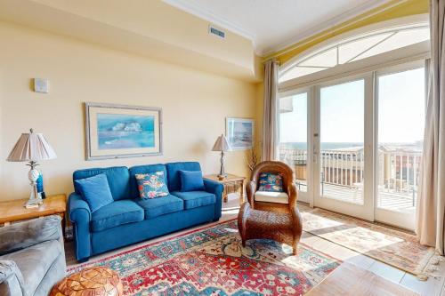 a living room with a blue couch and a window at South Beach 704 in Ocean City