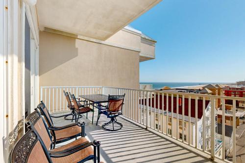 a balcony with chairs and a table with a view of the ocean at South Beach 704 in Ocean City