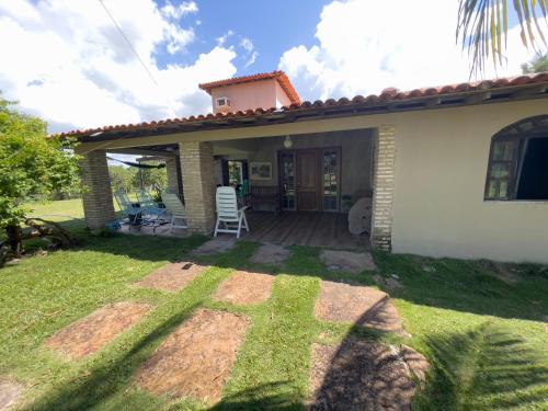 a small white house with a porch and a lawn at Sítio Encanto do Delta in Tutóia