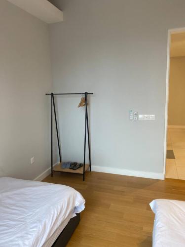 a bedroom with two beds and a white wall at SS KL Sentral by NomadNest in Kuala Lumpur
