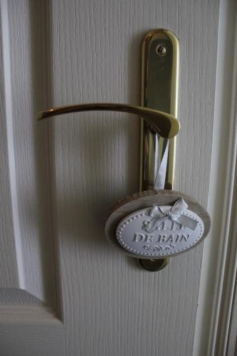a door handle with a sign on a door at L'Heure Bleue gîtes et chambres d'hôtes in Givenchy-en-Gohelle