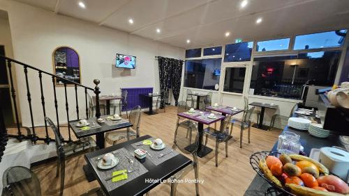 a room with tables and chairs and a room with a kitchen at Hôtel Le Rohan Charme et Caractère in Pontivy