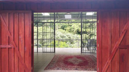 een open kamer met een rode deur met een tafel en een tapijt bij Maison tranquille in Rivas