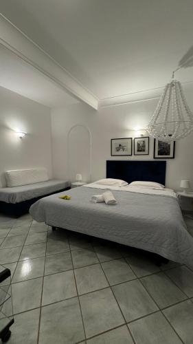 a bedroom with two beds and a chandelier at CAPRI DESIGN ROOM in Capri