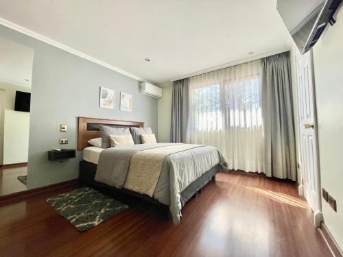 a bedroom with a bed and a large window at Olea's Home Las Condes in Santiago