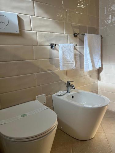 a bathroom with a white toilet and a sink at Coccinella B&B a Tufo in Tufo