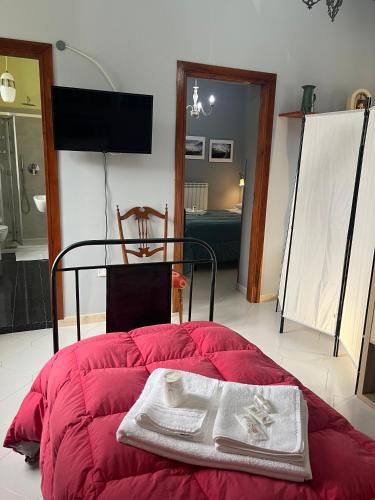 a red bed with towels on it in a room at Coccinella B&B a Tufo in Tufo