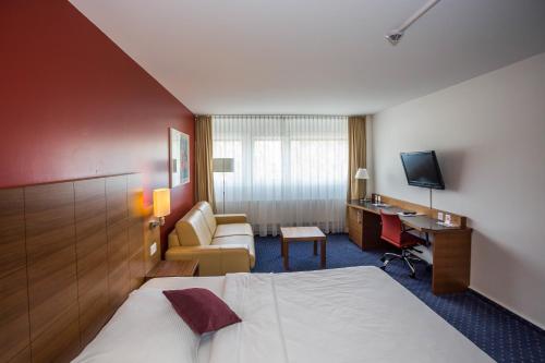 ein Hotelzimmer mit einem Bett und einem Schreibtisch in der Unterkunft Hotel Höri Inn in Höri