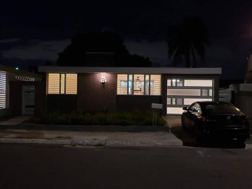 un coche aparcado delante de una casa por la noche en Encanto Caribeño en Levittown Lakes Puerto Rico, en Levittown