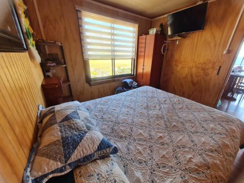 1 dormitorio con cama y ventana en Cabaña Atardecer Curiñanco, en Valdivia