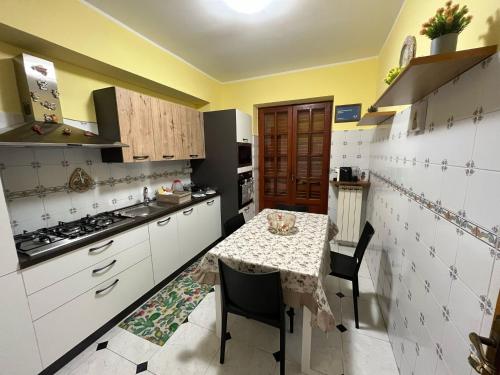 une petite cuisine avec une table, une table et des chaises dans l'établissement Appartamento Vico Matrice, à Gioiosa Marea