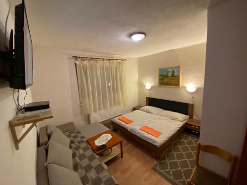 Penzión u Aďky في بوداجسكا: غرفة صغيرة بها سرير وأريكة