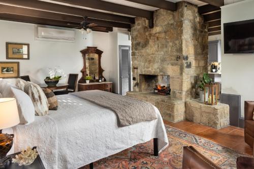 1 dormitorio con chimenea de piedra y 1 cama en Bayfront Marin House en Saint Augustine