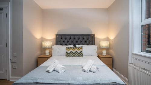 a bedroom with a large bed with two lamps at Queens Large 2 BDR & 1 BDR Apartments by Belfast City Breaks in Belfast