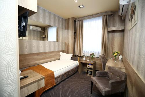 a hotel room with a bed and a desk and a chair at Hotel Forma in Piła