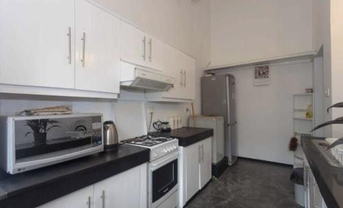 a kitchen with white cabinets and a stove top oven at 519@jamtree in Colombo