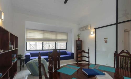 a living room with a blue couch and a table at 519@jamtree in Colombo