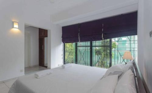 a bedroom with a bed and a large window at 519@jamtree in Colombo