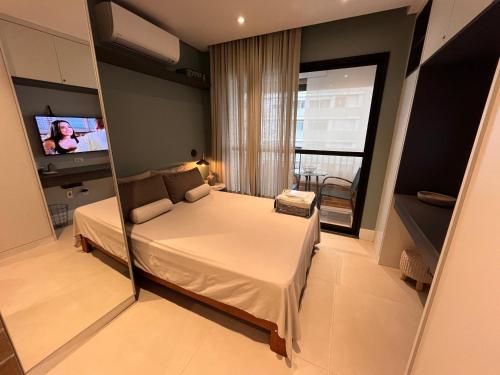 1 dormitorio pequeño con 1 cama y TV en Studio ANHANGABAÚ, en São Paulo