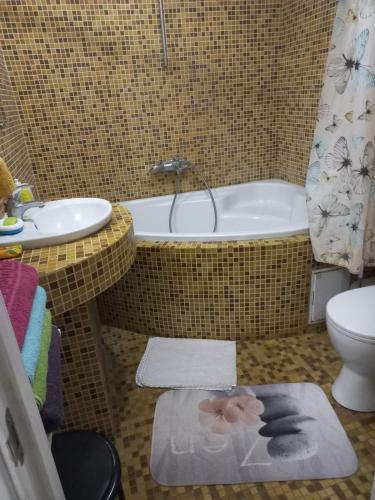 a bathroom with a tub and a toilet and a sink at Шикарная 2к квартира Центральный парк Университет 70м in Irpin'