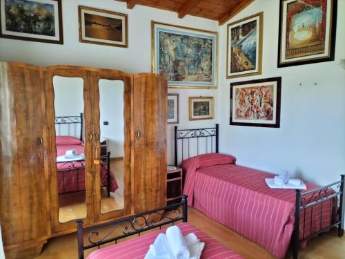 a bedroom with two twin beds and pictures on the wall at Agricola Baldo e Riccia - Fattoria e Agriturismo in Perugia