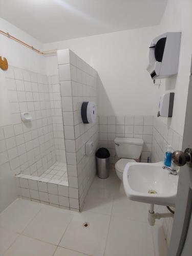 a white bathroom with a toilet and a sink at Amplias y Centricas Habitaciones Huaraz WIFI, AGUA CALIENTE in Huaraz