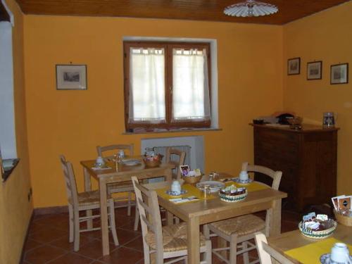 een eetkamer met tafels en stoelen en een raam bij IL Dahù in Pragelato
