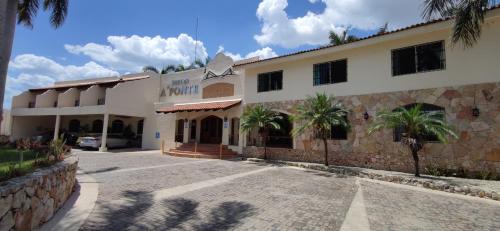 un edificio con palmeras delante en HOTEL A´PONTE, en Mérida