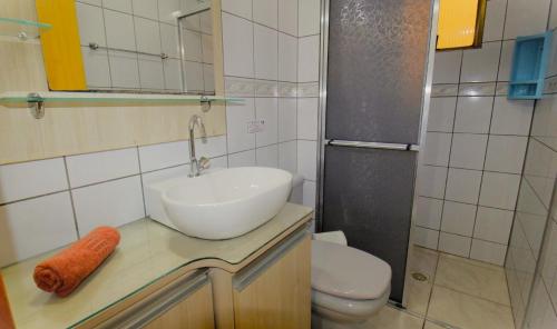 y baño con lavabo y aseo. en 1029 - Apartamento no centro de Bombinhas - Residencial estrela do mar 2 104 A, en Bombinhas
