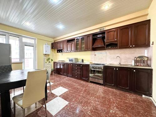 a large kitchen with wooden cabinets and a table at Bray Relax Home 2 in Farsala