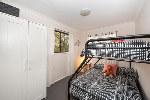 a bedroom with a bunk bed with a teddy bear on a pillow at Blue Starfish in Narrawallee