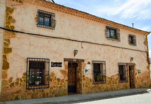 un antiguo edificio de piedra con ventanas y una puerta en Casa Rural Las Tejas, en El Picazo