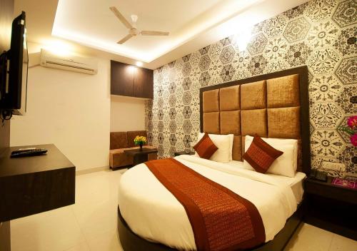 ein Schlafzimmer mit einem großen Bett in einem Zimmer in der Unterkunft Hotel Bellwood Grand Near Delhi IGI Airport in Neu-Delhi