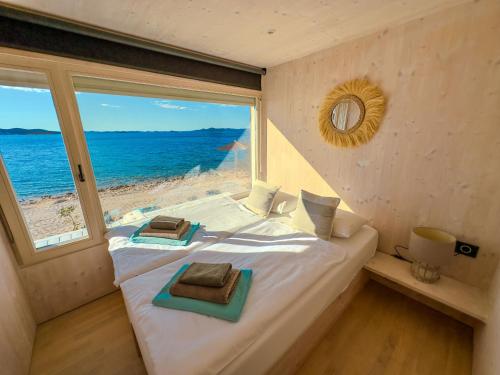 Schlafzimmer mit einem Bett und Meerblick in der Unterkunft Buqez Eco Resort - Beach Villa 22 in Drage