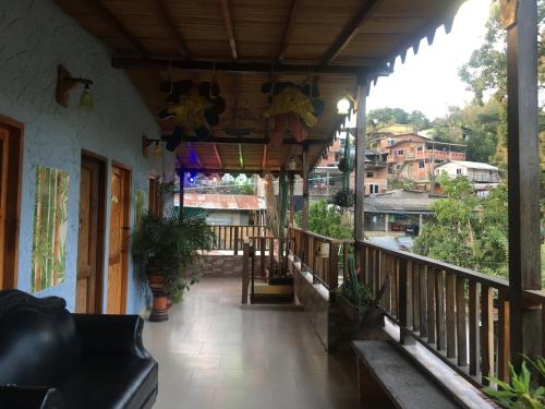 a porch of a house with a balcony at Hostal Los Wichos in Minca
