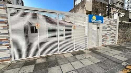 un edificio con un montón de puertas blancas de garaje en Pousada Praia Boa Viagem, en Recife