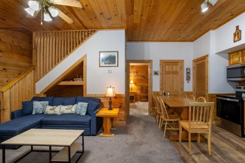 a living room with a blue couch and a table at 5 Mins to Pigeon Forge Strip w/ Hot Tub+Grill+MORE in Pigeon Forge