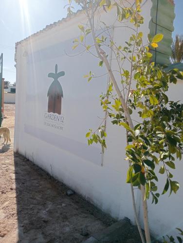 a sign on the side of a wall with a plant at Garden12 Outdoor & More in Douz