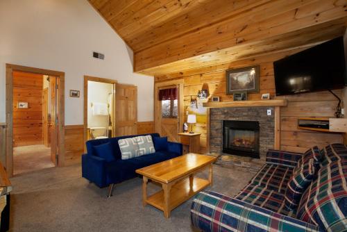 a living room with a blue couch and a fireplace at 5 Mins to Pigeon Forge Strip w/ Hot Tub+Grill+MORE in Pigeon Forge