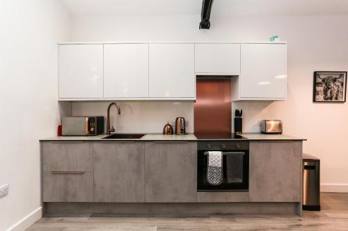 a kitchen with white cabinets and stainless steel appliances at Strawberry Line, Apartment 1 in Wells