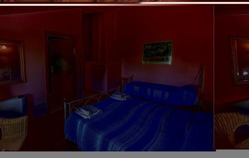 a bedroom with a blue bed in a red room at Villa Grimani in Il Rastello