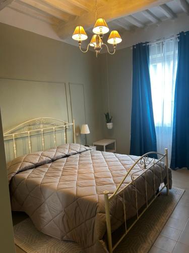 a bedroom with a large bed with blue curtains at Antica dimora in Borgo a Buggiano