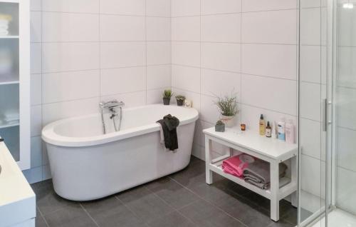 ein weißes Bad mit einer Badewanne und einer Dusche in der Unterkunft Lovely Home In Kristiansand S With House A Panoramic View in Kristiansand